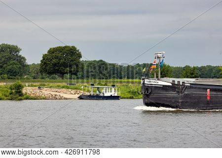 Arcen, The Netherlands - June 24, 2021: Small Ferry Crossing Dutch River Meuse Waiting For Large Car