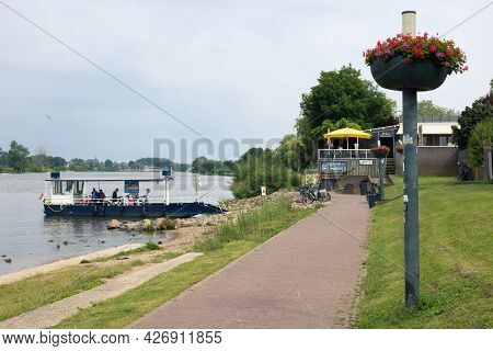 Arcen, The Netherlands - June 24, 2021: Small Ferry Crossing River Meuse Near Dutch Village Arcen