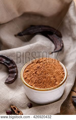 Dry Carob Pods And Carob Powder On Linen Napkin, Natural Background