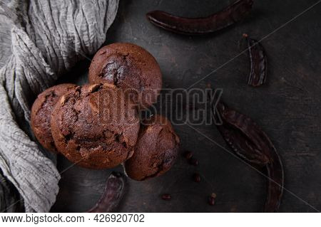 Chocolate Carob Cupcakes Cooking With Carob Powder And Dried Carob Pods On A Dark Background. Organi