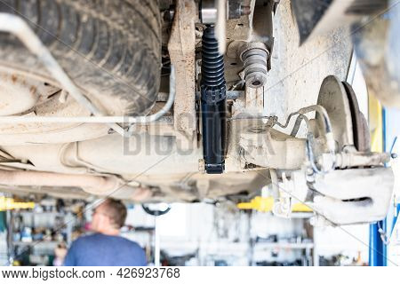 Bottom View Of Lifted Old Car With Replaced Rear Shock Absorber (focus On The New Rear Shock Absorbe