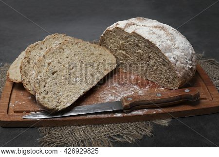 Homemade Bread From Coarse Flour With Spices, With Flax And Sunflower Seeds Cut On A Wood Board. Sou