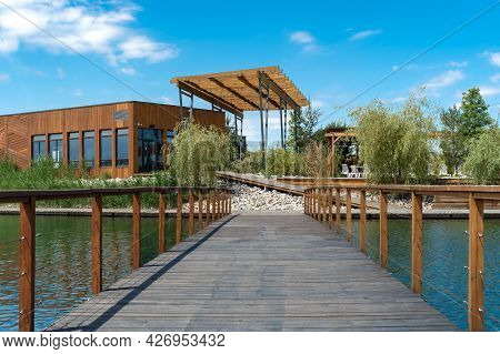 Wooden Bridge Across The Lake Leading To The Recreation Area
