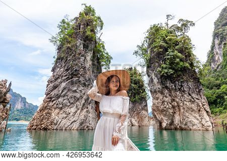 Happy Young Female Tourist In Dress And Hat At Longtail Boat Near Famous Three Rocks With Limestone 