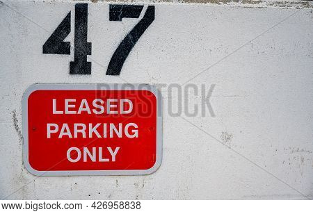 Leased Parking Sign With Assigned Number On A White Wall