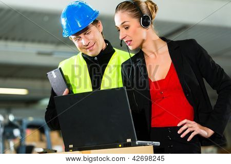 Teamwork - warehouseman eller en gaffeltruck chauffør og kvindelige tilsynsførende med laptop, headset og cell phone