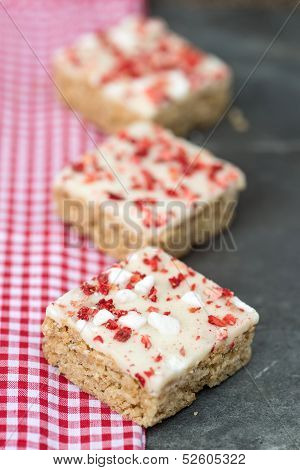 Strawberry And Meringue Topped Flapjack On Gingham Cloth