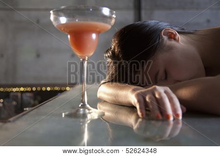 Young woman passed out on bar counter
