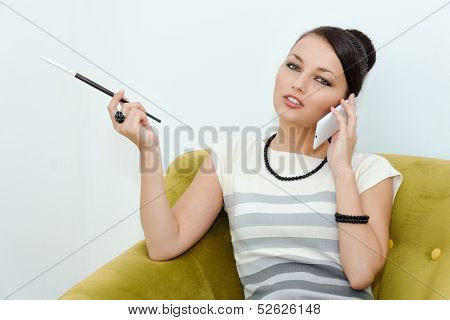 Young Woman Dressed In Retro Style With Cigarette Speaking On A Cell Phone