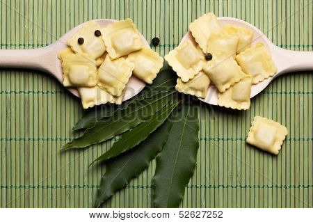 Italian pasta ravioli with flour eggs herbs on a spoon