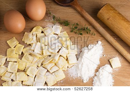 Italian pasta ravioli with flour eggs herbs and kitchen utensils