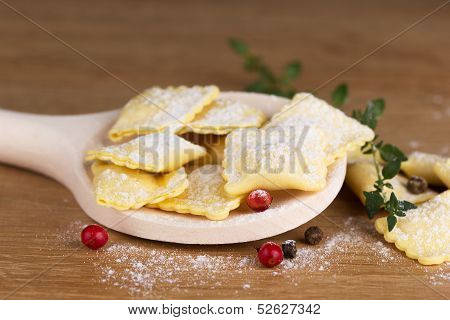 Italian pasta ravioli with flour eggs herbs on a spoon
