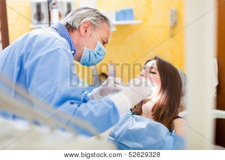 Dentist doing a dental treatment on a female patient