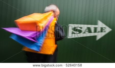 Holiday Sales. An Elderly Man With Many Shopping Bags In His Hand