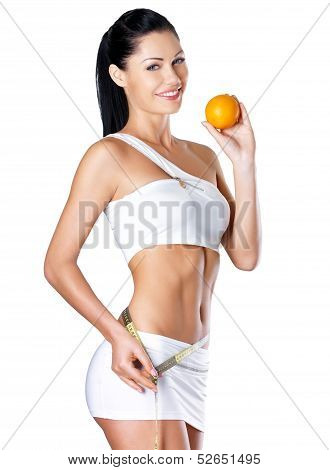 Smiling Girl Measures Figure With A Measuring Tape And Holding Orange