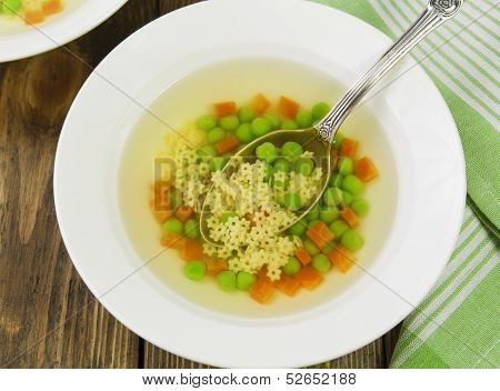 Soup With Star Shaped Noodles, Carrots And Green Peas