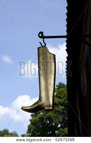 Metallic boot hangs on a hook.