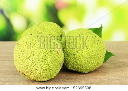 Osage Orange fruits (Maclura pomifera), on wooden table, on nature background