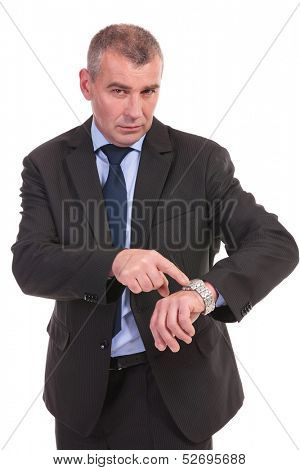 business man pointing at his watch and looking into the camera. on a white background
