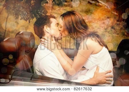 Beautiful couple kissing in back seat of a convertible