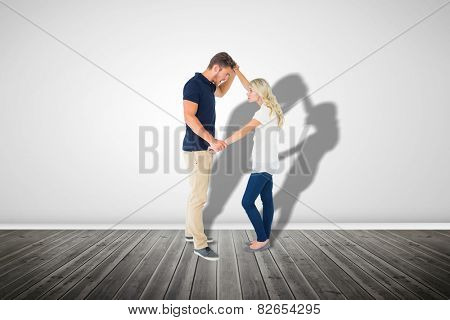 Angry man overpowering his girlfriend against grey room