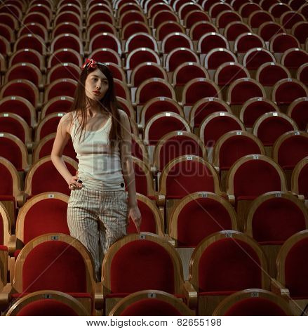 portrait of a pretty girl in a movie theater along, dreaming