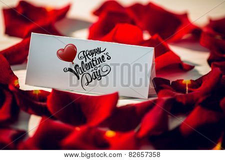 Cute valentines message against card surrounded by petals