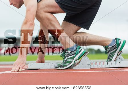 Side view of a man ready to race on running trac against stay motivated