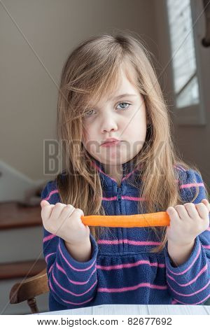 little unhappy girl with a carrot