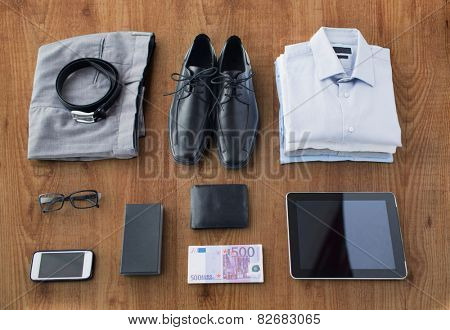 business, style, clothes and objects concept - close up of formal male clothes and personal stuff on wooden table at home