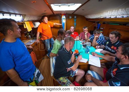 HYDRA, GREECE - CIRCA OCT, 2014: Unidentified sailors on skipper's briefing in the yacht wardroom during sailing regatta 12th Ellada Autumn 2014 among Greek island.