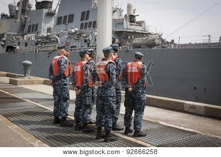 STATEN ISLAND, NY - MAY 20 2015: Sailors from NWS Earle Port Services wait to tend the lines of the guided-missile destroyer USS Barry (DDG 52)  as the ship docks at Sullivans Pier for Fleet Week NY.