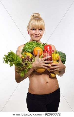 Attractive happy middle-age fit woman holding fruit and vegetables. Healthy eating, fitness, diet, vegetarianism and rawfoodist concept.