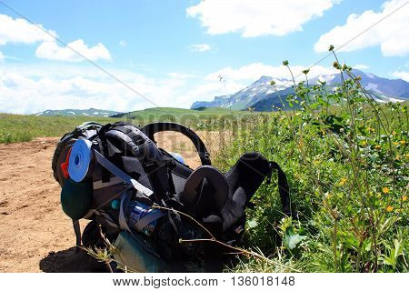 tourist backpack on a background of mountains road break holiday tourism.