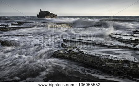 Shipwreck of an abandoned ship on a rocky coast at Akrotiri Beach in Cyprus