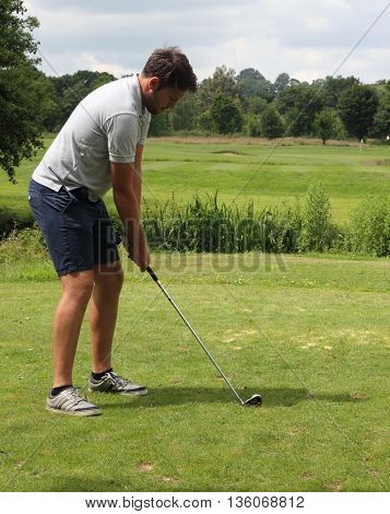 A golfer ready to hit the golfball onto the green of a par 3 on a golf course in okehampton, england