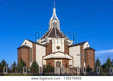 The modern Catholic church built of red brick.