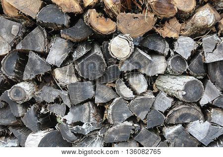 A large old pile of weathered fire wood.