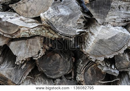 A large old pile of weathered fire wood.