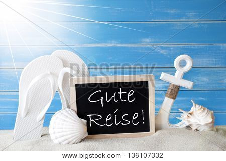 Chalkboard With German Text Gute Reise Means Good Trip. Blue Wooden Background. Sunny Summer Card With Holiday Greetings. Beach Vacation Symbolized By Sand, Flip Flops, Anchor And Shell.