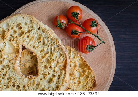 Italian dried bread Friselle on wooden board with tomatoes cherry. Italian food. Healthy vegetarian food.
