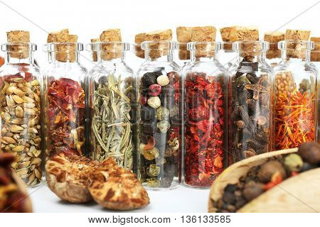 Assorted dry spices in glass bottles, close up