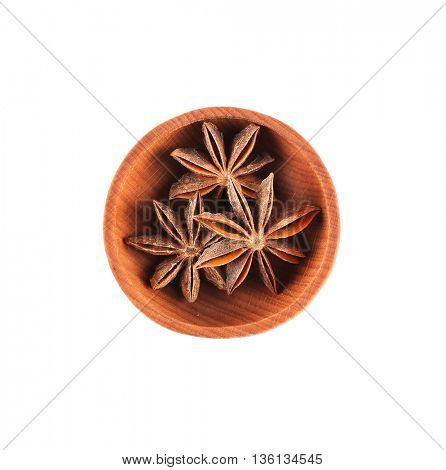 Star anise spice in small wooden bowl isolated on white