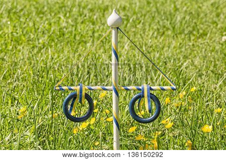 Ornament Maypole in Grass with buttercup flowers.