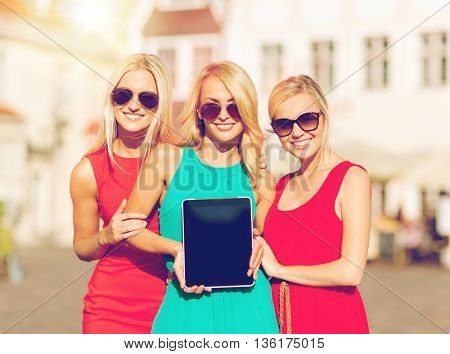 holidays and tourism concept - beautiful blonde girls toursits showing tablet pc with blank screen in the city