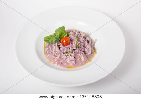 Purple itlian rice dish with cherry tomato and basil