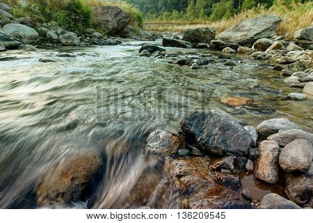 Beautiful Reshi River water flowing on rocks at dawn Sikkim India - a spectacular view tinted image
