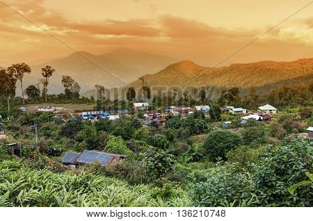 Beautiful view of Silerygaon Village with Kanchenjunga mountain range at the background at orange colored dusk light at Sikkim India
