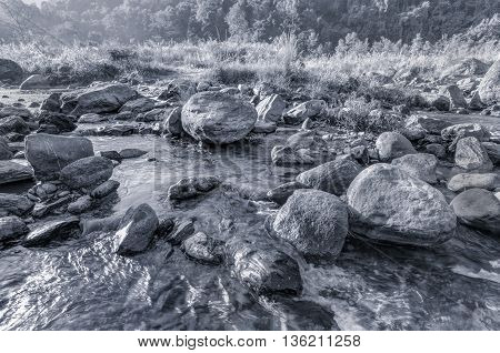 Beautiful Reshi River water flowing on rocks at dawn Sikkim India - a spectacular view tinted image