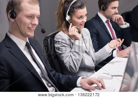 Focused telephone consultants talking with their clients and working on computers